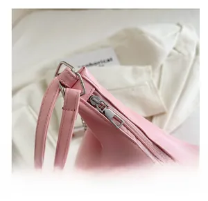 Detail shot of the smooth silver zipper and stitching on the light pink tote bag