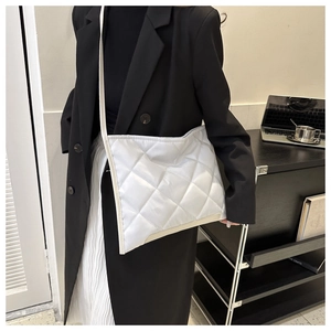 Détail d'un sac bandoulière blanc matelassé avec surpiqûres losanges sur mannequin