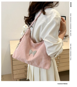 Detail of light pink wrinkled nylon shoulder bag with silver butterfly and metal chain