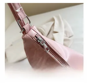 Detail of pink shoulder bag with smooth silver metal zipper and textured faux leather