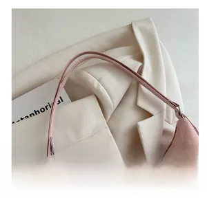 Detail of pink PU leather handbag with soft pleated texture and silver hardware connectors