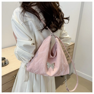 Detailed view of pink pleated shoulder bag featuring a decorative silver metal butterfly