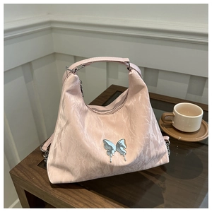Close-up of pink pleated hobo bag with metallic butterfly buckle and chain strap