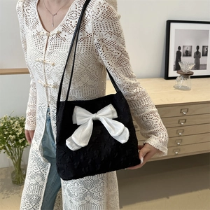 Sac fourre-tout noir chic avec un grand nœud en satin blanc et texture plissée