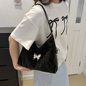 Black crinkled leather underarm bag with silver butterfly charm and chain detail