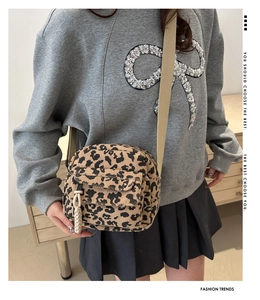 Detailed texture of leopard print corduroy crossbody bag with woven rope buckle detail
