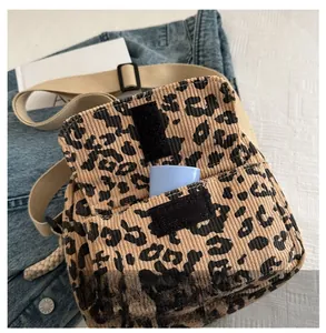 Detail view of leopard print corduroy crossbody bag with front pocket and velcro flap