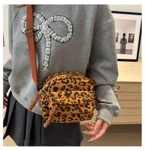 Détail d'un sac bandoulière en velours côtelé léopard avec sangle marron et poche avant