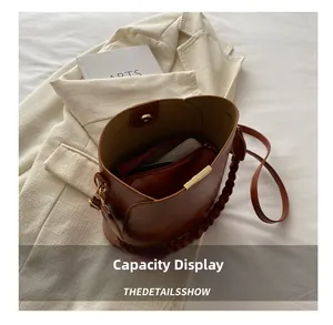 Top view of brown leather bucket bag with magnetic closure and inner zipper pouch