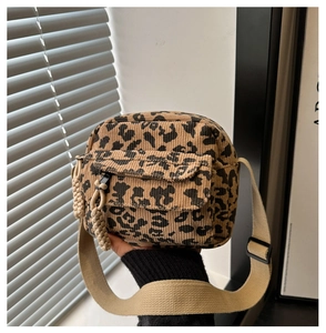 Gros plan du sac bandoulière léopard en velours côtelé avec fermeture tressée et poche