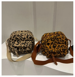 Detail of leopard print corduroy crossbody bags showing texture and braided zippers