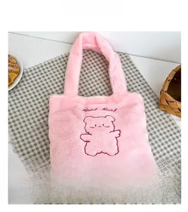 Détail du sac seau en peluche rose montrant la fausse fourrure et la broderie d'ours