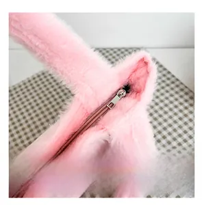 Gros plan sur la fermeture éclair en métal et le tissu en peluche rose du sac seau