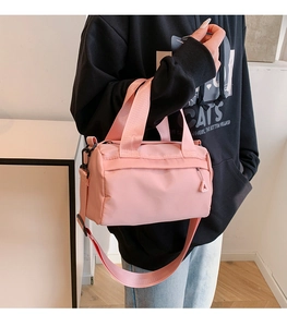 Pink nylon duffle bag detail featuring adjustable shoulder strap and matte hardware