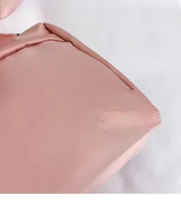 Close-up of pink twill fabric texture and precise stitching on the mini square handbag