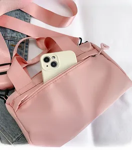 Detail of pink nylon shoulder bag featuring front zipper pocket and smartphone storage