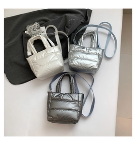Close-up of quilted puffer bags in pearl white, silver, and metallic grey with shiny finish