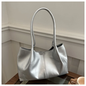 Close-up of metallic silver tote bag with fine stitching and slim leather shoulder straps