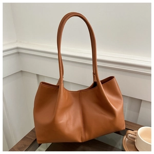 Detailed view of brown PU leather tote bag texture and soft stitching on the side