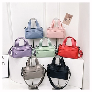 Detailed display of colorful nylon crossbody bags in seven vibrant tones on tiered stands