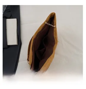 Detailed interior of brown suede tote bag with zipper closure and two pockets