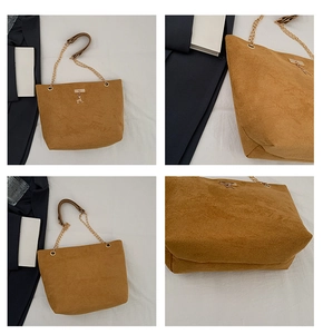 Detail of brown suede tote bag with gold chain strap and metallic deer charm accent
