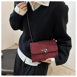 Vue détaillée du sac bandoulière en daim bordeaux avec chaîne argentée et fermoir chic