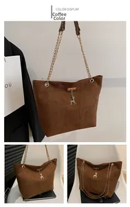 Detail of coffee suede tote bag featuring a gold chain strap and deer pendant ornament