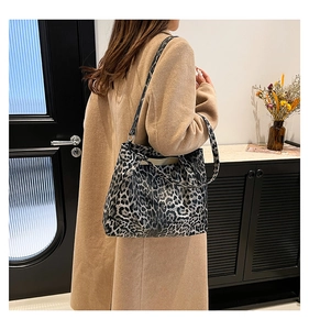 Detail of the large leopard print tote bag being worn on shoulder with brown coat