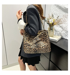 Detail view of large leopard print tote bag styled on model in modern room