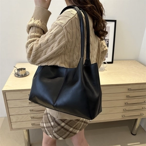 Minimalist black leather tote bag with vertical stitching for daily commute