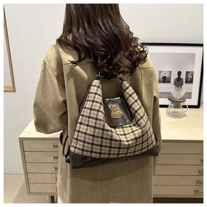 Détail du sac cabas en toile avec un écusson ours brodé en 3D et un motif à carreaux