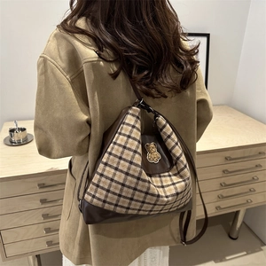 Sac hobo rétro à carreaux avec broderie ours et finitions en cuir marron sur modèle