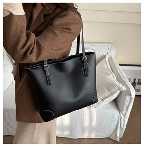 Detail van zwarte leren shopper met witte contraststiksels en gouden gespen luxe