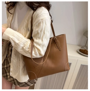 Detailopname van de caramel lederen shopper met witte contraststiksels op de hoeken