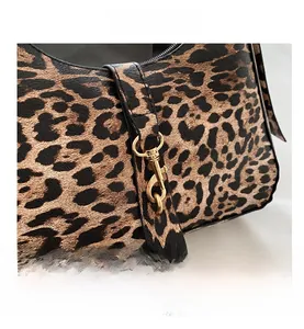Gros plan du sac à main léopard avec fermoir mousqueton doré et texture cuir grainé