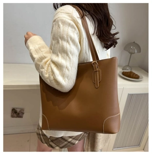 Detail van een bruine shopper met contraststiksels op een herfstschoudertas