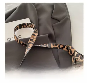 Gros plan d'un sac à main léopard avec détails métalliques dorés et texture premium