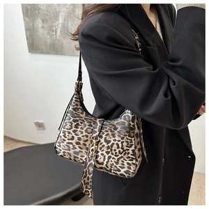 Sac sous le bras à imprimé léopard avec boucle dorée présenté sur l'épaule d'un mannequin