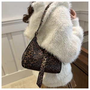 Détail du sac léopard avec fermoir en métal doré et bandoulière chaîne sur modèle