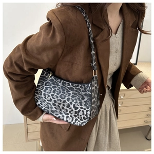 Dettaglio della borsa a mezzaluna leopardata sulla spalla con finitura vintage