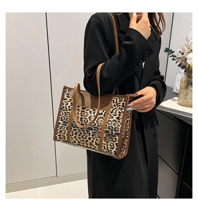 Leopard print tote bag with brown leather handles styled with a black blazer