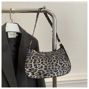 Detail of grey leopard print shoulder bag with crescent shape and gold zipper detail