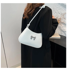 Détail du sac à bandoulière blanc avec nœud argenté et bandoulière en corde tressée