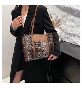 Detail of leopard print tote bag with brown leather straps and spacious interior