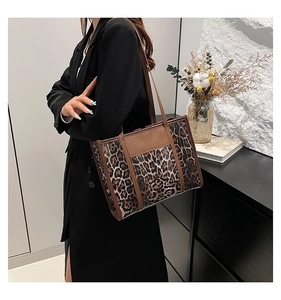 Close-up of leopard print tote bag with brown leather handles and spacious design