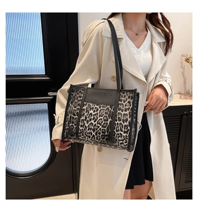 Detailed view of leopard print tote bag styled with a beige trench coat for a chic office look