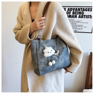 Detail of smoky gray marble tote bag with chain strap and plush cloud charm