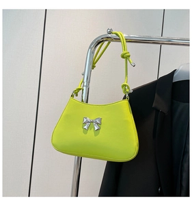 Gros plan du sac à main jaune néon avec boucle nœud argentée et bandoulière nouée