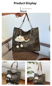 Detail of vintage black tote bag with chain strap and cute cloud plush charm pendant